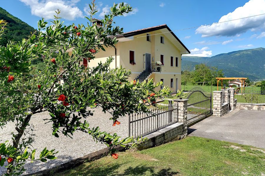 La casa gialla di Casa Aria Pura con il giardino, ad Alano di Piave