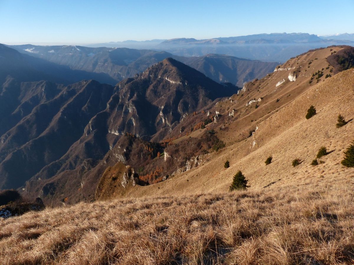 I prati sommitali della Val Sassuma con le creste rocciose che scendono verso la valle.